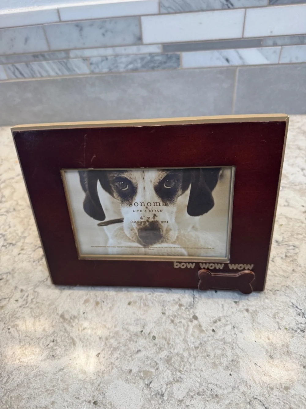 A Sonoma Life & Style brown wood picture frame with dog bone and bow wow wow